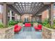 Outdoor seating area with pergola, stone columns, and comfortable red furniture at 901 Abernathy Ne Rd # 3020, Atlanta, GA 30328