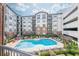 Beautiful community pool area surrounded by lounge chairs, lush landscaping, and a charming building exterior at 901 Abernathy Ne Rd # 3020, Atlanta, GA 30328