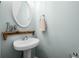 Stylish half-bathroom featuring a pedestal sink and a decorative mirror at 240 Daisy Cir, Mcdonough, GA 30252