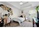 Well-lit bedroom with decor above the bed and desk, mirror, plants, and a comfortable bed for relaxation at 240 Daisy Cir, Mcdonough, GA 30252