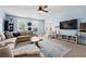Bright living room with large windows, plush sectional sofa, and a modern entertainment center at 240 Daisy Cir, Mcdonough, GA 30252