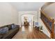 Inviting living room with hardwood floors, an archway leading to the kitchen, and a staircase with iron railings at 240 Daisy Cir, Mcdonough, GA 30252