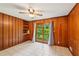 Relaxing bedroom highlighting wood paneled walls, a ceiling fan, and a backyard view at 2880 Shallowford Rd, Chamblee, GA 30341