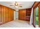 Comfortable bedroom featuring wood paneling, a built-in shelf, and sliding glass doors at 2880 Shallowford Rd, Chamblee, GA 30341