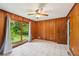 Cozy bedroom with wood paneled walls, a ceiling fan, and sliding glass doors to the backyard at 2880 Shallowford Rd, Chamblee, GA 30341