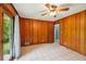 Inviting bedroom with wood paneled walls, a ceiling fan, and large windows at 2880 Shallowford Rd, Chamblee, GA 30341