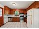 Charming kitchen featuring wood paneling, white appliances, and tile floors at 2880 Shallowford Rd, Chamblee, GA 30341