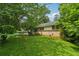 Spacious side yard with lush green grass and mature trees providing shade and privacy to the property at 2880 Shallowford Rd, Chamblee, GA 30341
