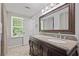Bathroom featuring double sinks, a large mirror, tile floors and plenty of natural light at 9470 Hillside Dr, Roswell, GA 30076