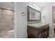 Bathroom featuring double sinks, a large mirror, a tiled shower and a toilet at 9470 Hillside Dr, Roswell, GA 30076