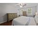 Bright bedroom featuring hardwood floors, ceiling fan and two dressers with built in shelving at 9470 Hillside Dr, Roswell, GA 30076
