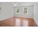 Spacious bedroom with hardwood floors, ceiling fan, and windows providing ample natural light at 9470 Hillside Dr, Roswell, GA 30076