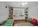 Bright bedroom with built-in shelving, plush carpet, and large window overlooking the backyard at 9470 Hillside Dr, Roswell, GA 30076