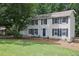Two-story home with white siding, blue shutters, well-manicured lawn and mature trees at 9470 Hillside Dr, Roswell, GA 30076