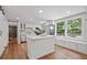 Bright kitchen featuring white cabinets, stainless steel appliances, and hardwood floors at 9470 Hillside Dr, Roswell, GA 30076
