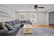 Bright living room with neutral walls, hardwood floors, and a large blue sectional sofa at 9470 Hillside Dr, Roswell, GA 30076