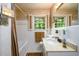 Cozy bathroom with tub and shower, floral wallpaper, hexagon tile flooring, and natural lighting at 2518 Foster Ridge Ne Ct, Atlanta, GA 30345