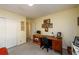 Bedroom featuring neutral carpet, closet and desk area, accented with various hanging photographs at 2518 Foster Ridge Ne Ct, Atlanta, GA 30345