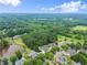 Aerial view of a quiet neighborhood next to a lake, surrounded by beautiful lush greenery at 4526 Meadow Club Dr, Suwanee, GA 30024