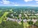 An aerial view of an upscale residential area with mature trees, well-maintained lawns, and waterfront homes on a lake at 4526 Meadow Club Dr, Suwanee, GA 30024