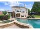 Stunning backyard with a pool, spa, and an elegant home exterior, designed for upscale outdoor living and entertaining at 4526 Meadow Club Dr, Suwanee, GA 30024