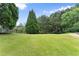 Manicured lawn with a backdrop of mature trees, showcasing a serene and private outdoor space at 4526 Meadow Club Dr, Suwanee, GA 30024