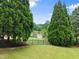 Beautifully landscaped backyard with lush lawn and a scenic view of the serene lake at 4526 Meadow Club Dr, Suwanee, GA 30024