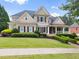 Beautiful two-story home with manicured lawn, shrubbery, and classic architectural details at 4526 Meadow Club Dr, Suwanee, GA 30024