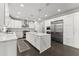 A modern white kitchen features a large island, stainless steel appliances, and dark wood flooring at 4526 Meadow Club Dr, Suwanee, GA 30024