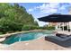 A beautiful pool area with stone accents, surrounded by comfortable lounge chairs and lush greenery at 4526 Meadow Club Dr, Suwanee, GA 30024