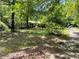 View of the driveway leading up to the house and partially obscured by trees at 4701 Cleveland Rd, Lithonia, GA 30038