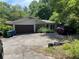 Attached garage with a driveway, showing a car parked and some landscaping at 4701 Cleveland Rd, Lithonia, GA 30038