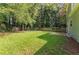 Large, green backyard with wood fence and a small patio area at 620 Waynes Se Ct, Atlanta, GA 30354