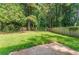 Fenced backyard with vibrant green grass and mature trees at 620 Waynes Se Ct, Atlanta, GA 30354