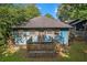 Charming, blue cottage-style home with a wooden deck and stairs, nestled among lush greenery at 730 Brownwood Se Ave, Atlanta, GA 30316