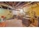 Unfinished basement area with painted brick, work benches, open ceiling, and space for workshop at 730 Brownwood Se Ave, Atlanta, GA 30316