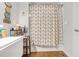 Bathroom shower with white and gold curtain, wood-look flooring, and wall decor at 730 Brownwood Se Ave, Atlanta, GA 30316