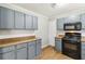 The kitchen features a black appliance package, laminate countertops, gray cabinetry, and wood flooring at 924 Sweetwater Cir, Lawrenceville, GA 30044