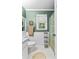 Green bathroom featuring a shower with patterned curtain, window, and tile flooring at 119 Castlewood Rd, Tyrone, GA 30290