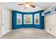 Well-lit bedroom featuring blue walls, built-in shelves, and large windows at 119 Castlewood Rd, Tyrone, GA 30290
