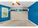 Well-lit bedroom featuring blue walls, built-in shelves, and large windows at 119 Castlewood Rd, Tyrone, GA 30290
