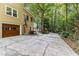 Exterior side view with a spacious driveway leading to a garage and views of lush greenery at 119 Castlewood Rd, Tyrone, GA 30290