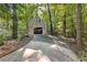 Exterior of detached garage and driveway nestled amongst a forest of trees at 119 Castlewood Rd, Tyrone, GA 30290
