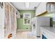 Functional laundry room with washer, dryer, shelving, and natural light from a window at 119 Castlewood Rd, Tyrone, GA 30290