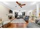 Spacious living room boasts hardwood floors, brick fireplace, plush gray sectional, and a ceiling fan at 119 Castlewood Rd, Tyrone, GA 30290