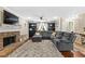 Comfortable living area featuring plush gray sectional, brick fireplace, built-in shelving, and a ceiling fan at 119 Castlewood Rd, Tyrone, GA 30290