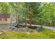 Beautiful exterior with a charming pond and detached garage nestled amongst mature trees at 119 Castlewood Rd, Tyrone, GA 30290