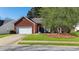 Charming brick home with a well-maintained lawn, mature tree, and two-car garage at 175 Robin Ct, Fayetteville, GA 30215