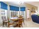 Eat-in kitchen with white cabinets, three large windows, and a view to the living room at 175 Robin Ct, Fayetteville, GA 30215