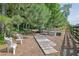 Serene backyard featuring multiple seating areas, a wooden walkway, and mature trees at 3320 Pleasant Springs Dr, Cumming, GA 30028
